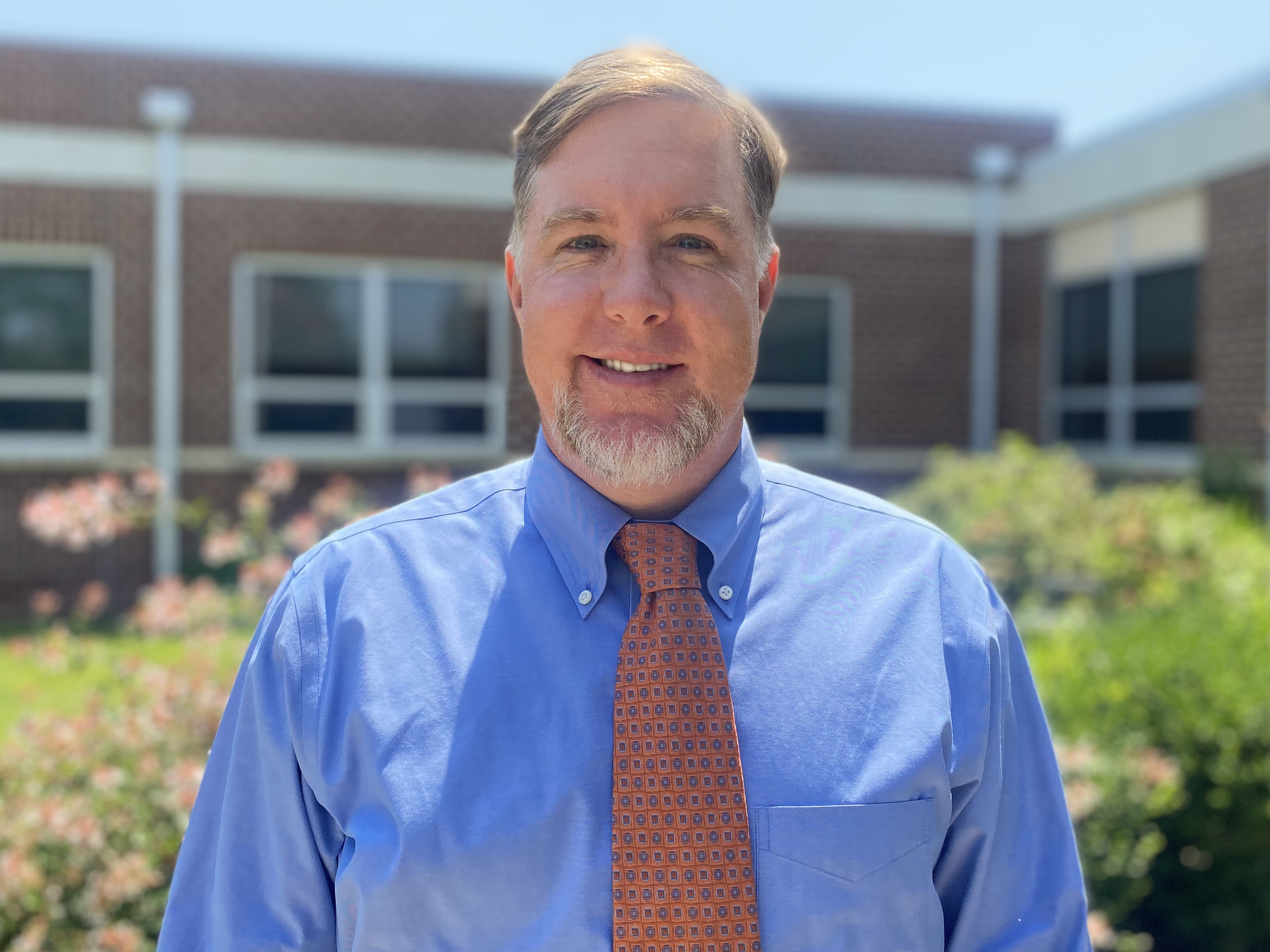 Assistant Principal Donald Robertson posing for a photo outside of the school.