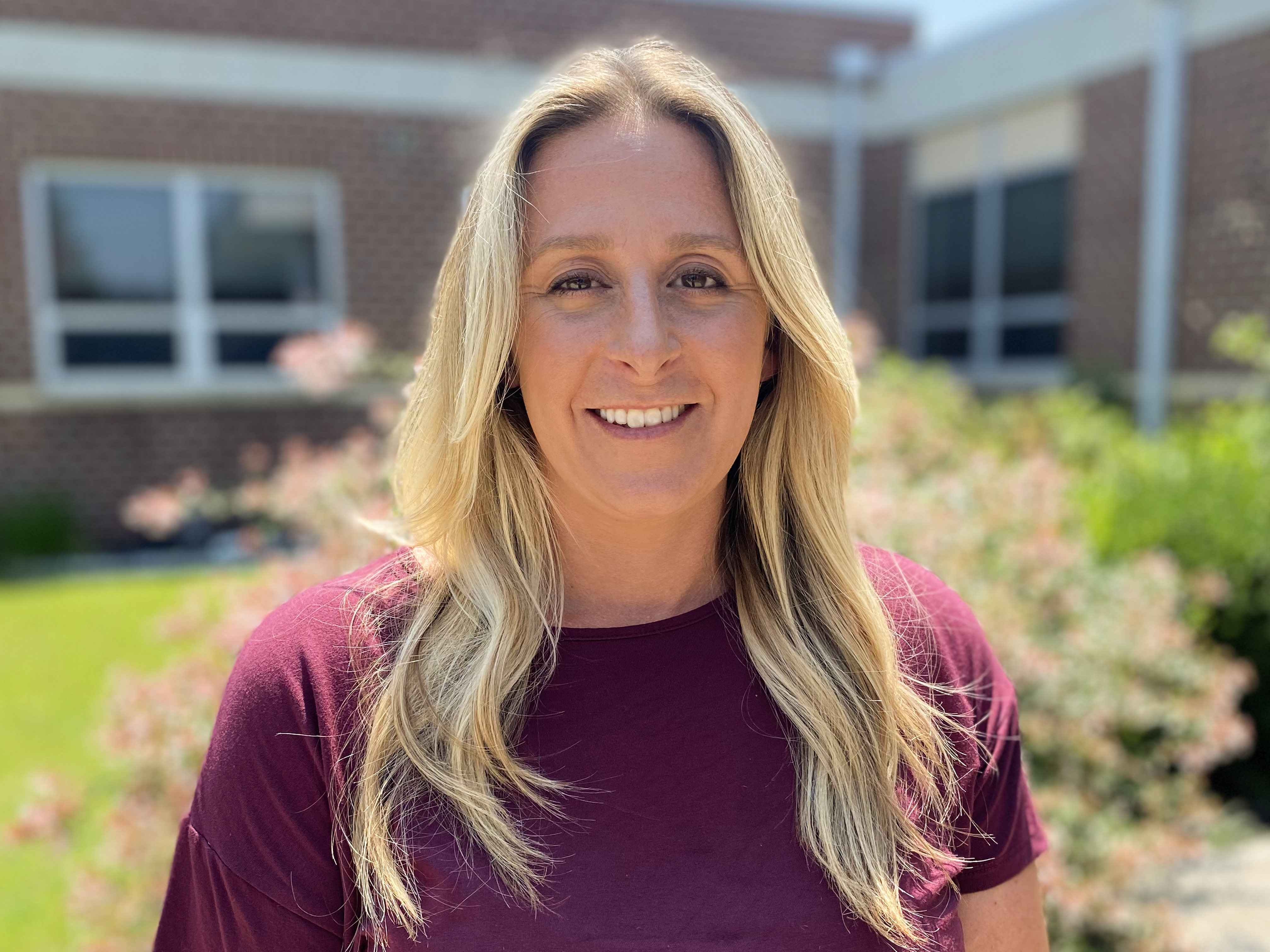 Instructional Supervisor Katherine Taylor posing for a photo outside of the school.